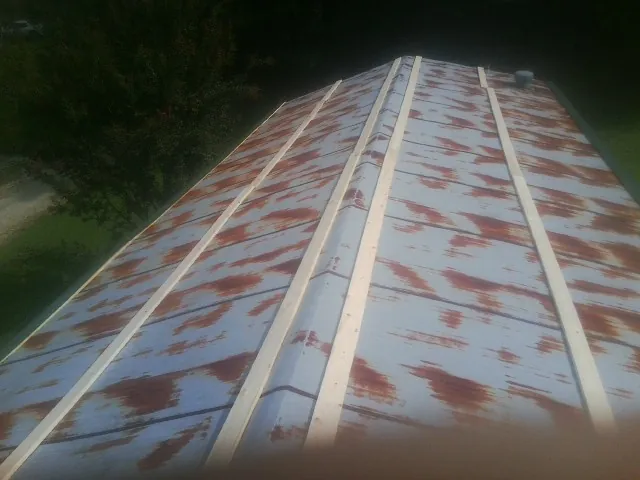 Rusted metal roof panels with new wood purlins before replacement — Storm Damage Roof Repair in Winterthur by Roofing Brothers